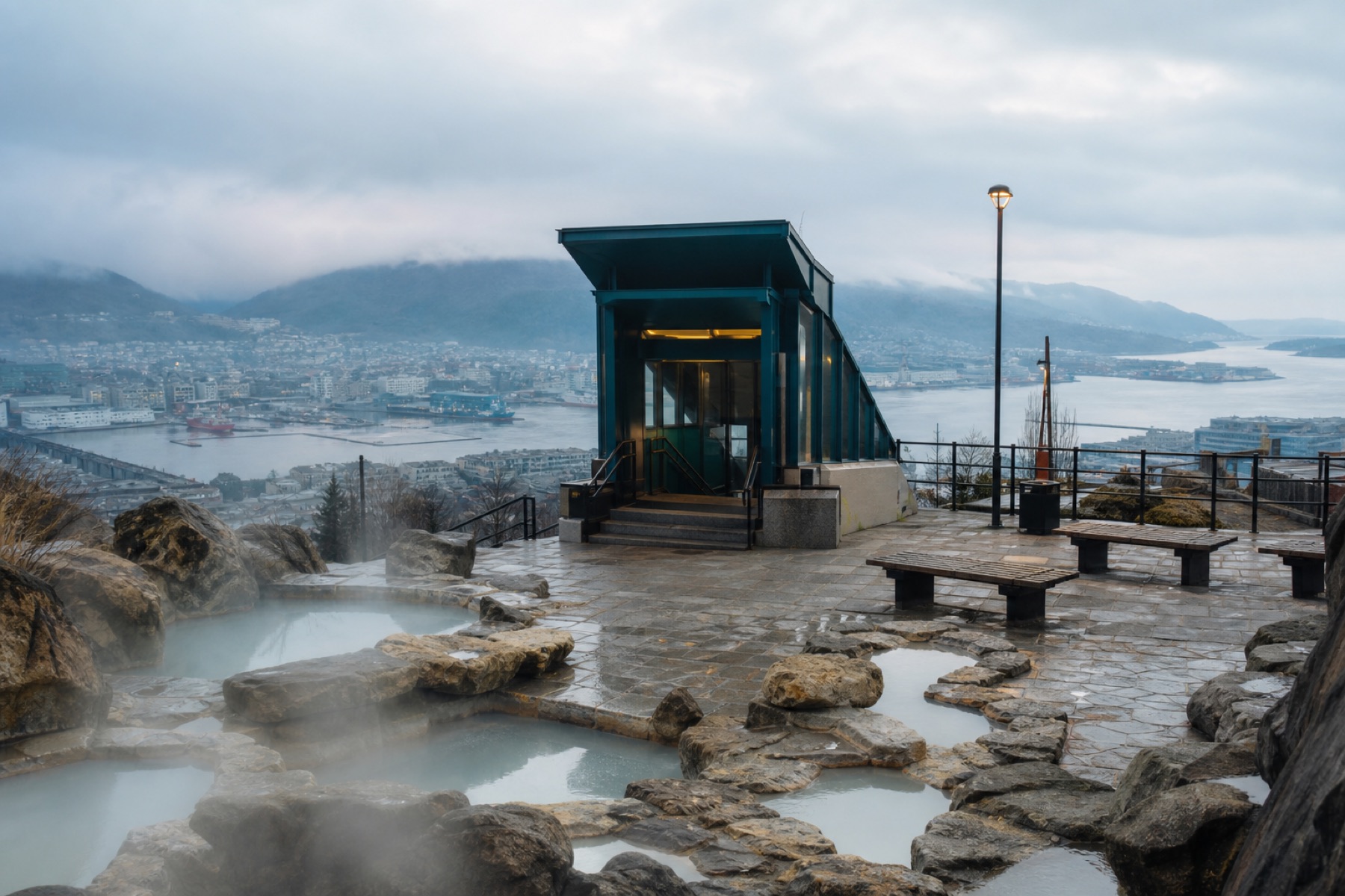 Municipal stone basins of volcanic spring water on a terrace, with a teal metro entrance beyond.